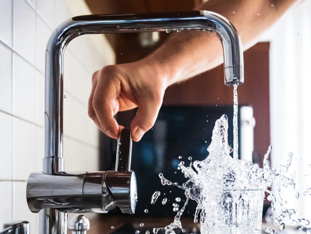 蛇口から勢いよくグラスに水が注がれる瞬間