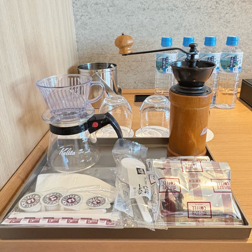 函館湯の川温泉 海と灯/ヒューイットリゾートのジュニアスイート客室にあるコーヒーミル、ドリッパー、ミネラルウォーターなど
